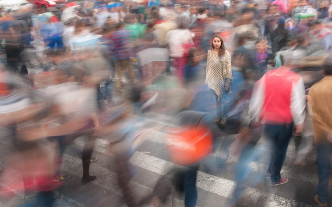 Being in the moment: woman standing still with people moving all around her
